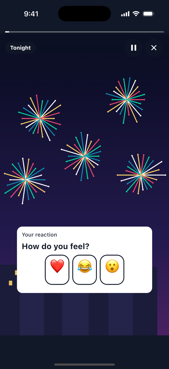 Screenshot of a TaleArt sample reaction on iOS over fireworks on a night sky: a white card titled 'Your reaction' with the question 'How do you feel?' and three emoji buttons, a heart, a laughing face and a surprised face, before a tap.